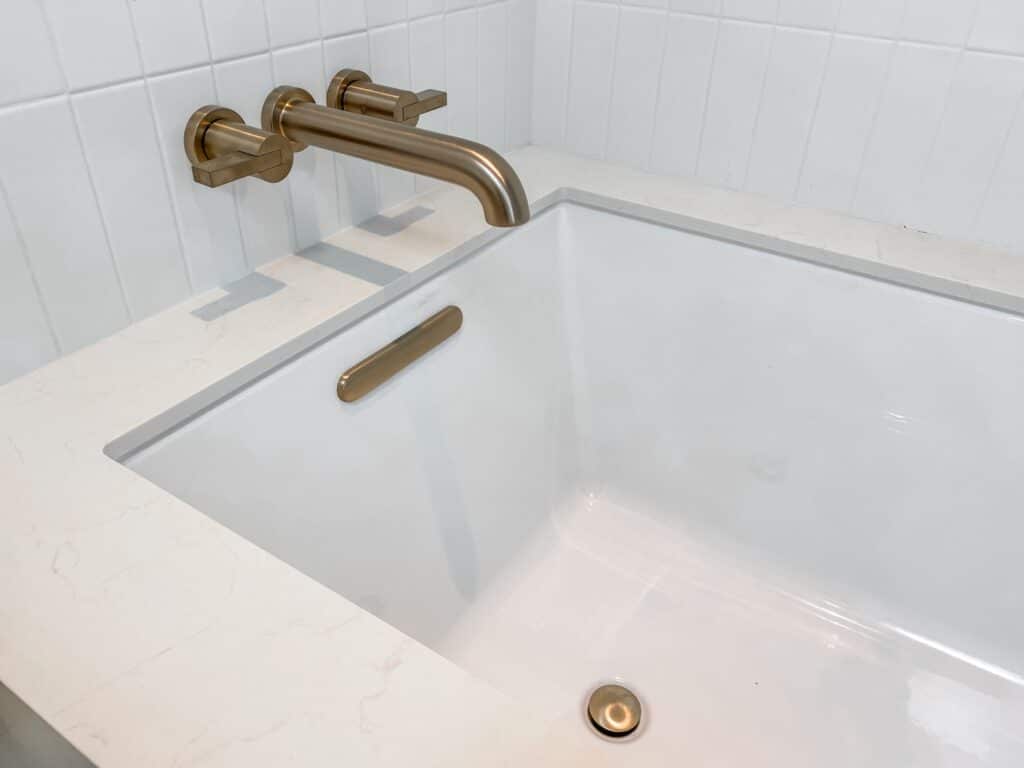 A White Bathtub with a Golden Faucet