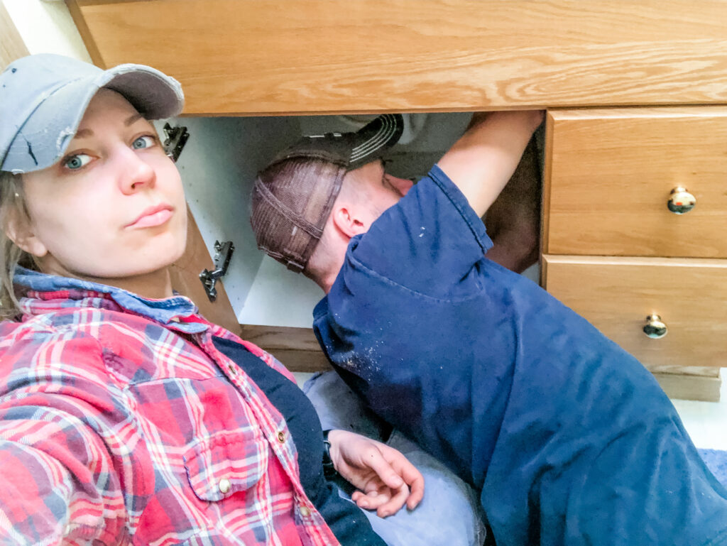 Plumbers working on sink high angle